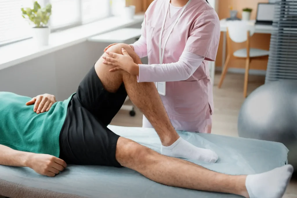 Physical therapist performing a manual knee examination on a patient.