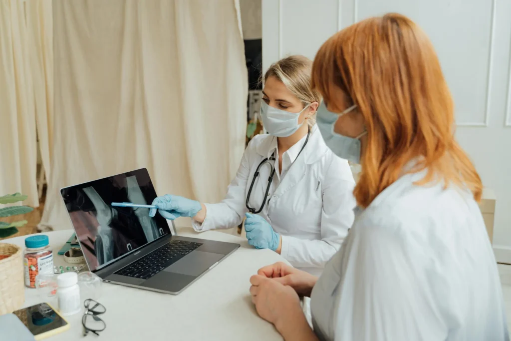 Physician showing a patient digital X-rays of a knee joint