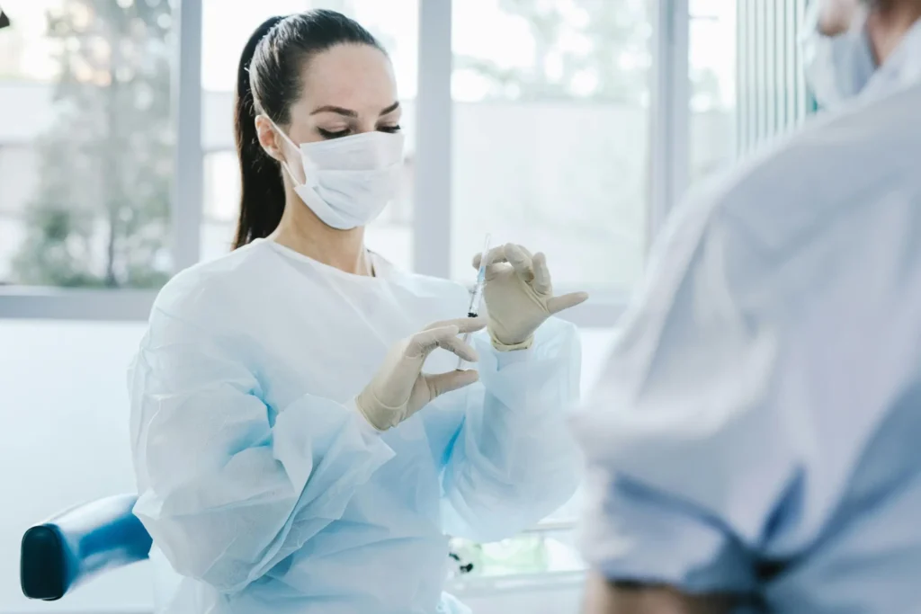 Female clinician preparing a medical injection for a patient.